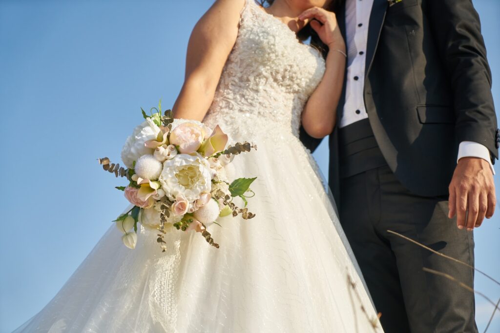 woman in white wedding dress holding bouquet of white flowers